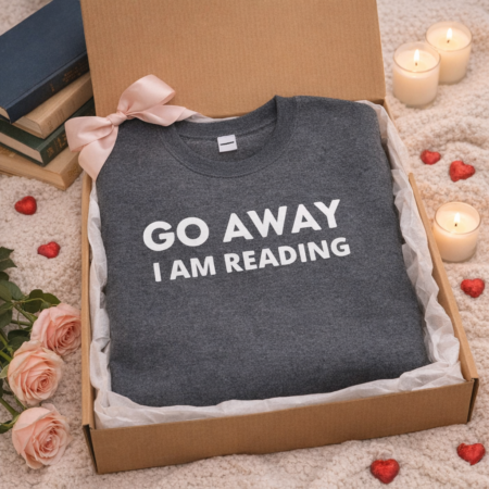 A sweatshirt in a gift box that says 'Go away Im reading'