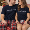 Matching couples red & navy tartan pyjamas that say Merry Christmas