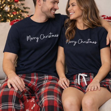 Matching couples red & navy tartan pyjamas that say Merry Christmas