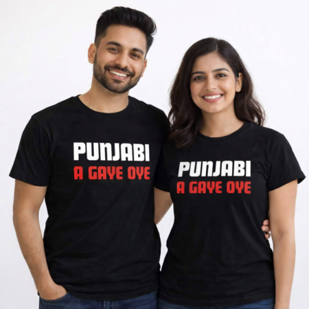 Indian couple in their early 30s wearing matching black T‑shirts printed with the phrase ‘PUNJABI A GAYE OYE’ — the word ‘PUNJABI’ appears in white and ‘A GAYE OYE’ in red, both smiling against a plain white background