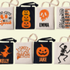 Personalised Halloween trick or treat tote bags with custom names, available in black and natural cotton featuring pumpkin, ghost, witch and skeleton designs.