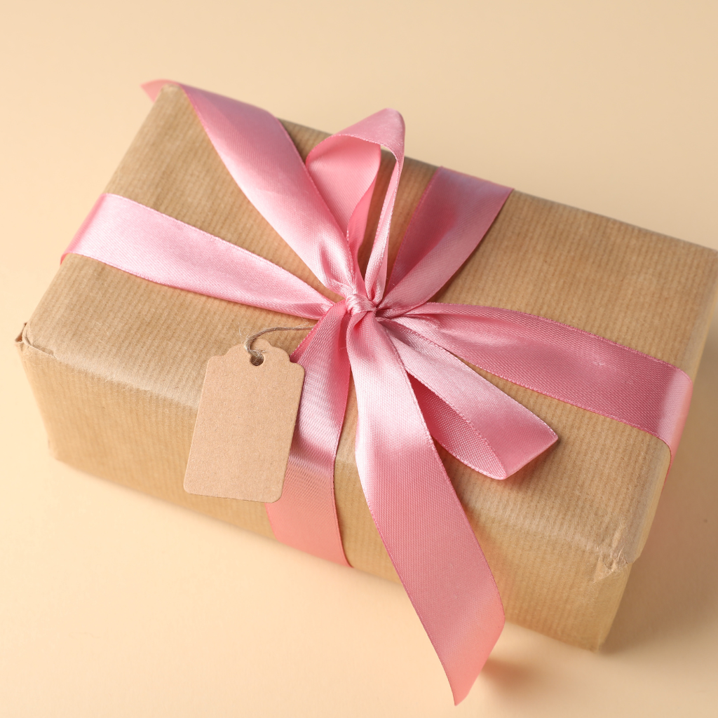 Beige background Gift box with a pink ribbon